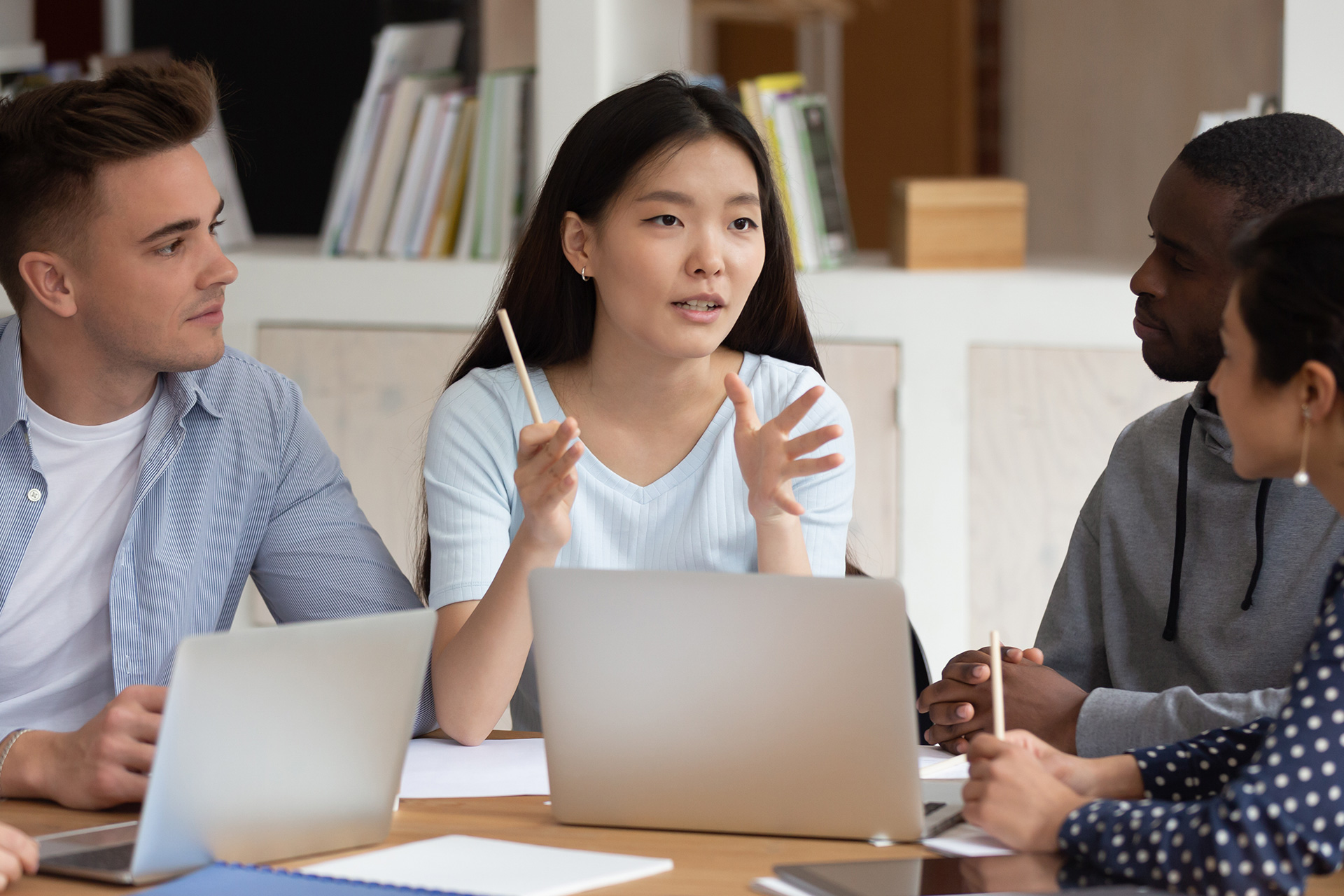 A team of employees discusses anti-Asian racism in the workplace and work together to overcome it.