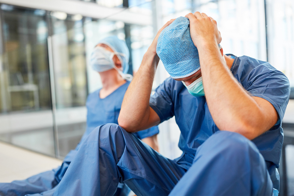 A front line health care worker sits alone and tries to calm their own emotions in between supporting their team.