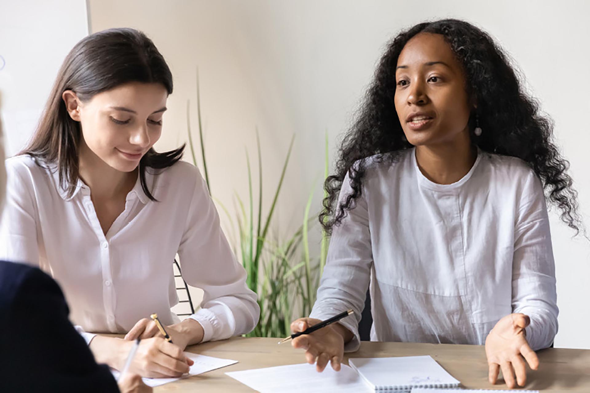 Plusieurs employés s'assoient à une table et discutent de la façon de résoudre le problème de la discrimination au travail.