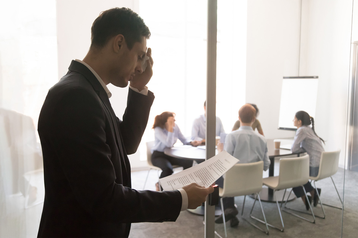 Un gestionnaire se tient à l'extérieur d'une salle de conférence et passe en revue ses notes sur la façon d'être un leader efficace.