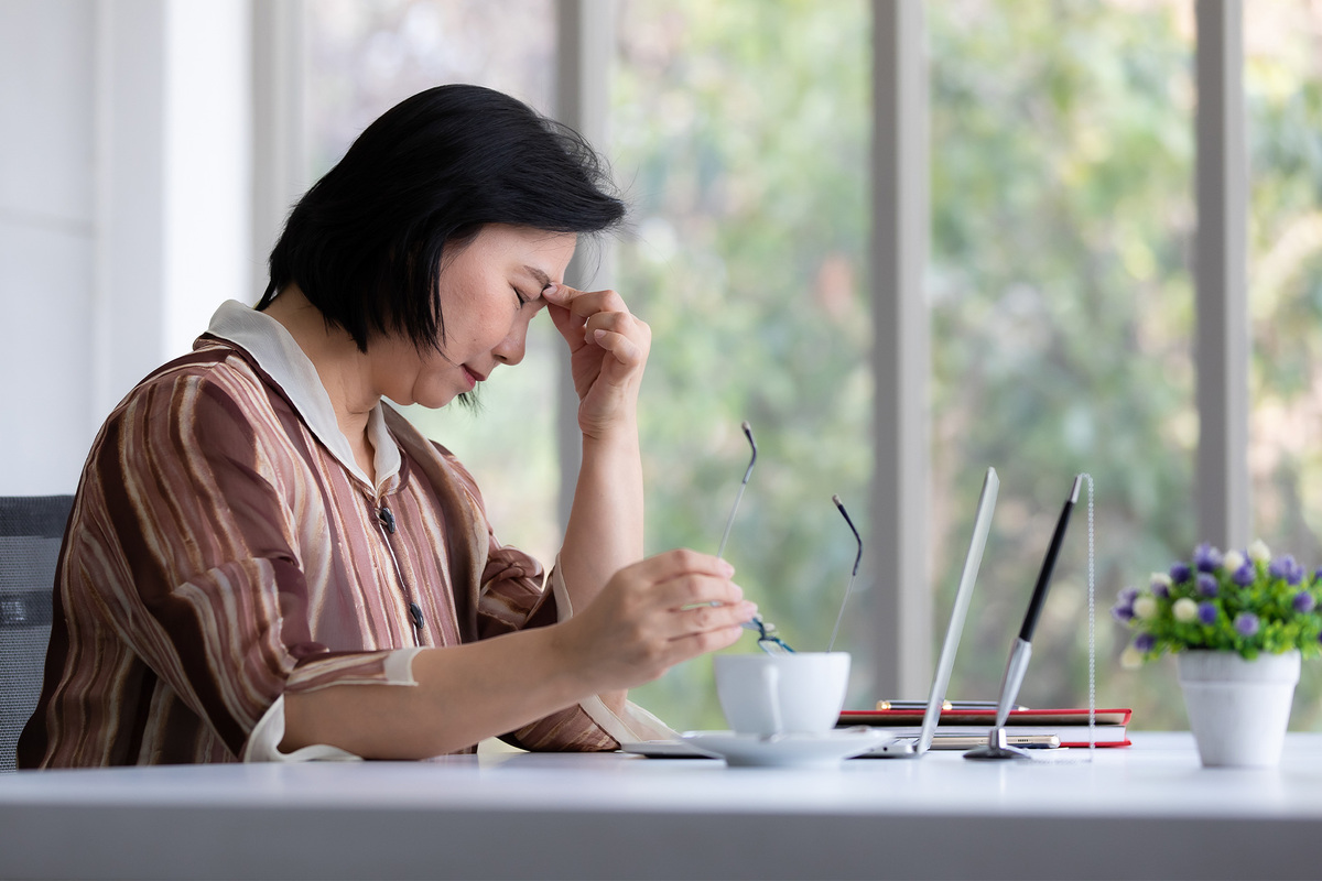 older asian woman looking sad and tired