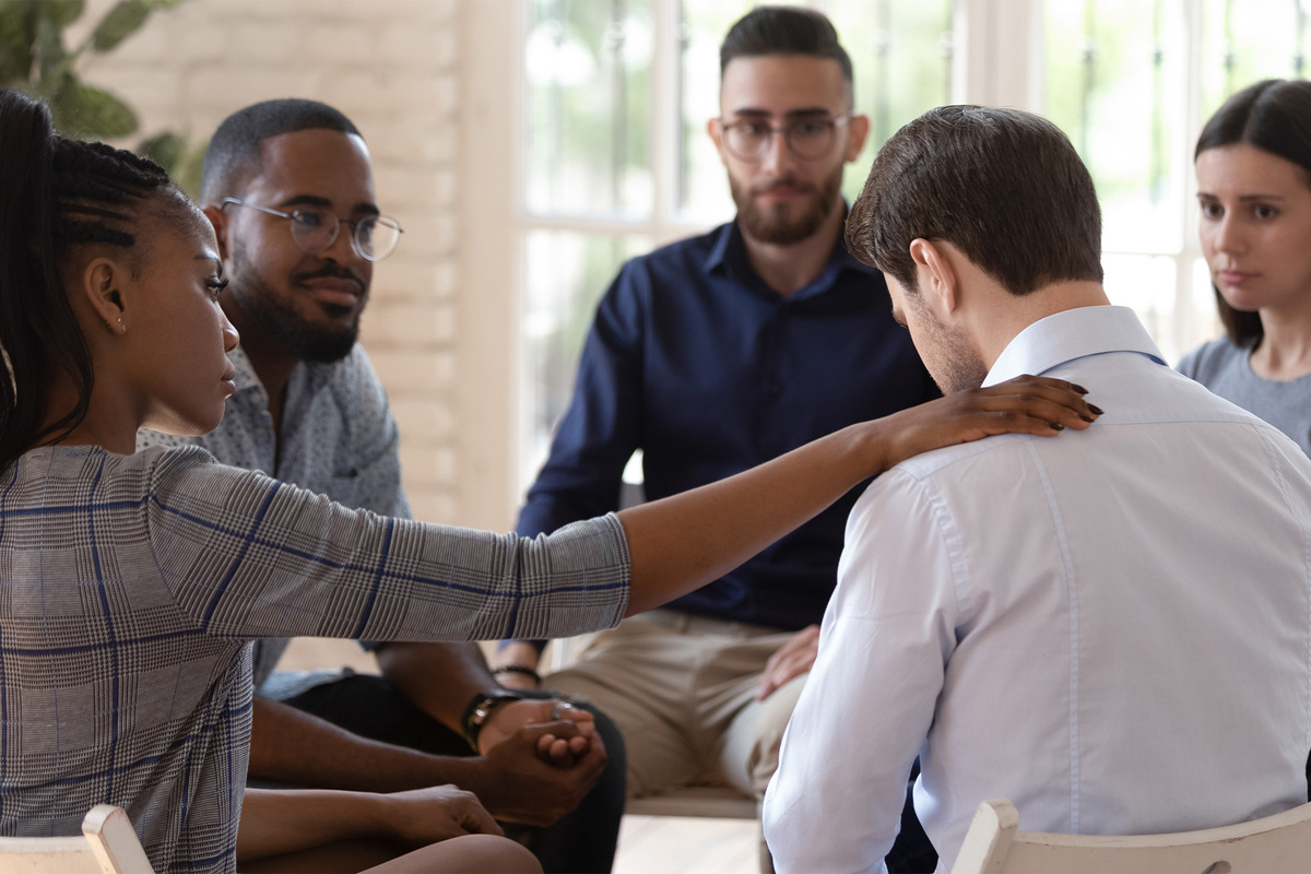 A group of employees sits together and supports one another through substance use challenges.