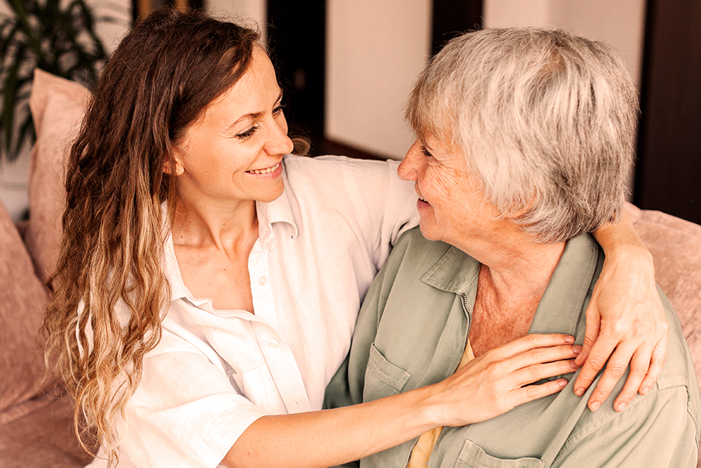 Older mature mother and grown millennial daughter laughing embracing, caring smiling young woman embracing happy senior middle aged mom