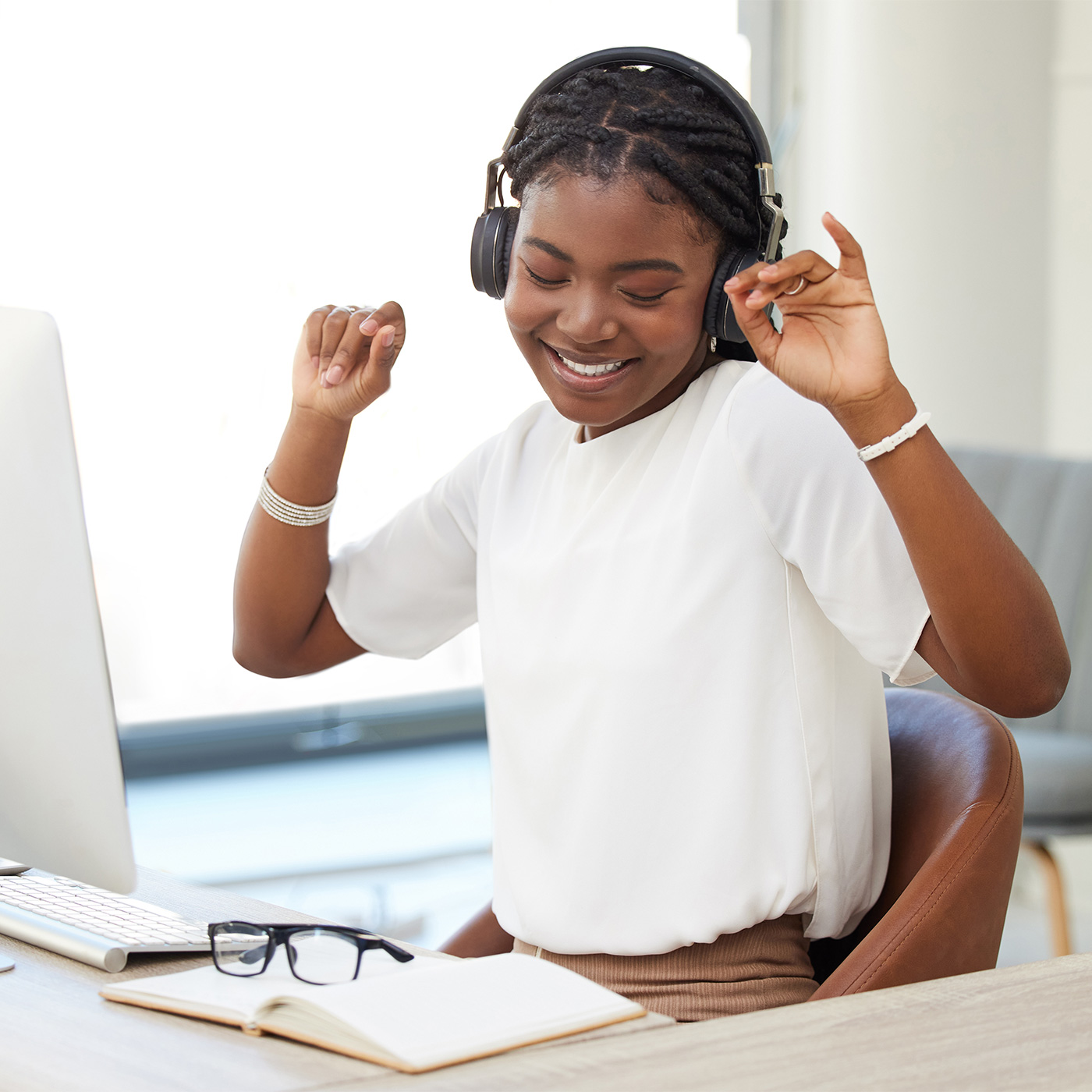 happy woman wearing headphones at her desk
