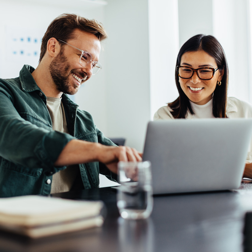 Two people happy at a desk