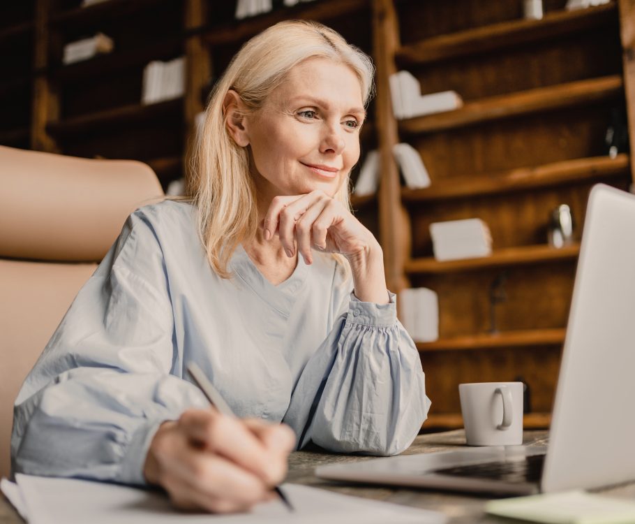 Woman working on laptop in a cozy library setting.