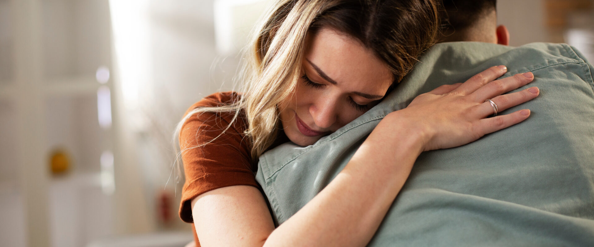 Woman embracing a person warmly, conveying comfort and emotional support.