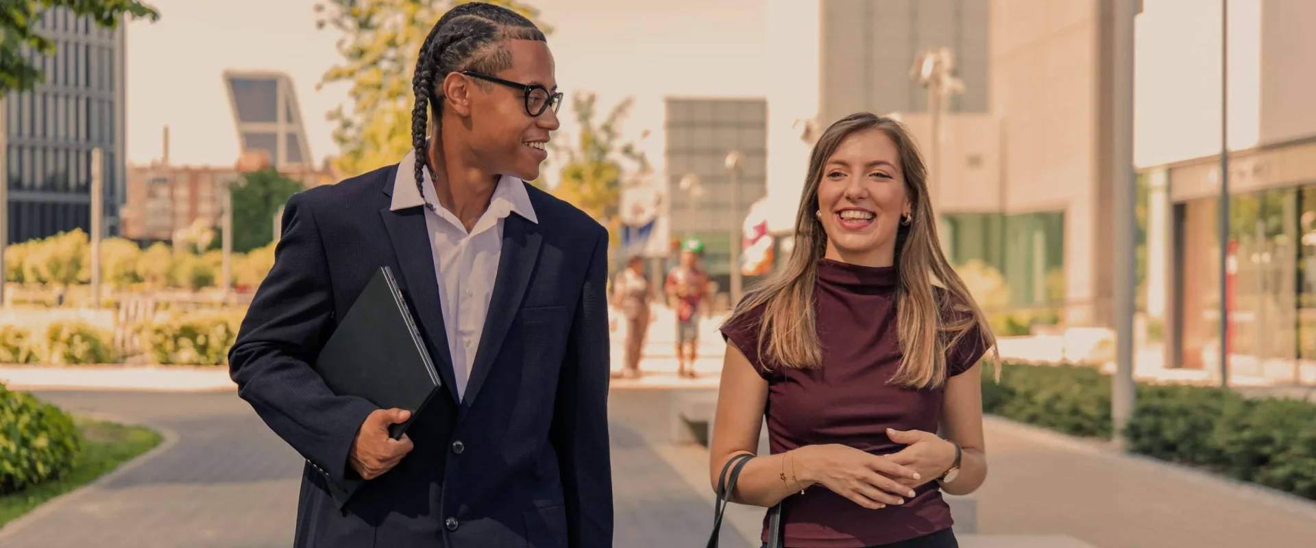 Young professionals walking and talking in a modern city setting.