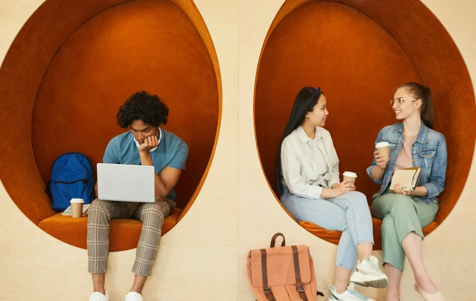 People in cozy pods: man using laptop, two women chatting over coffee. Collaborative workspace.