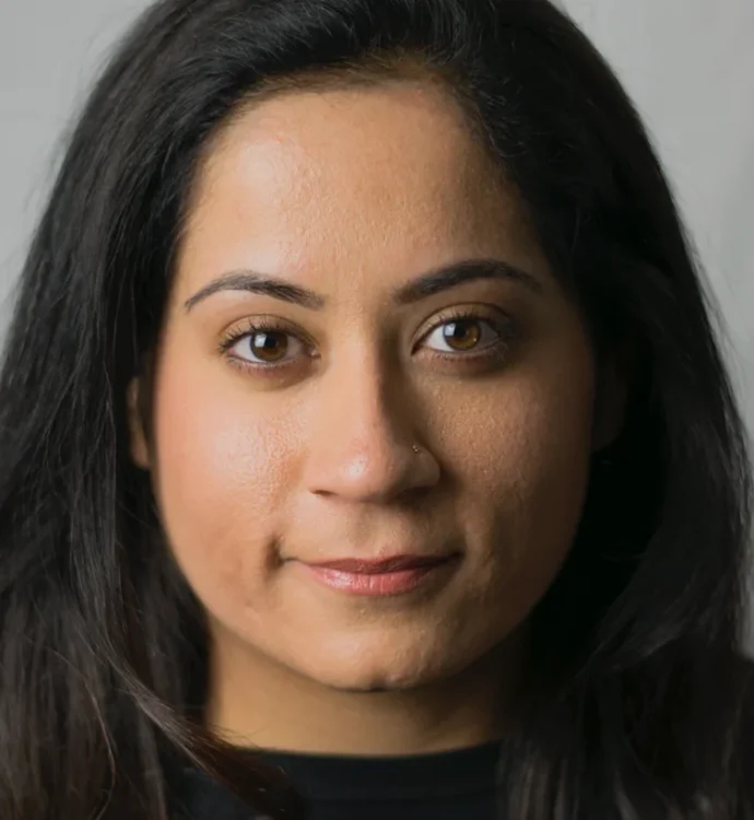 Portrait of a woman with long dark hair against a neutral background.
