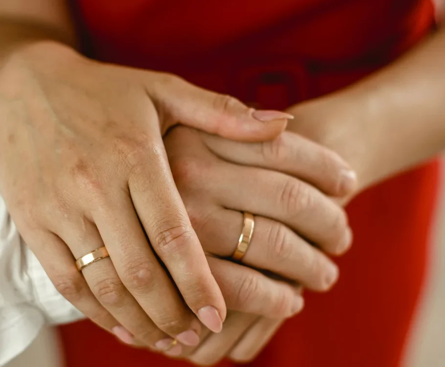 Hands with gold wedding rings symbolizing love and commitment between two people.