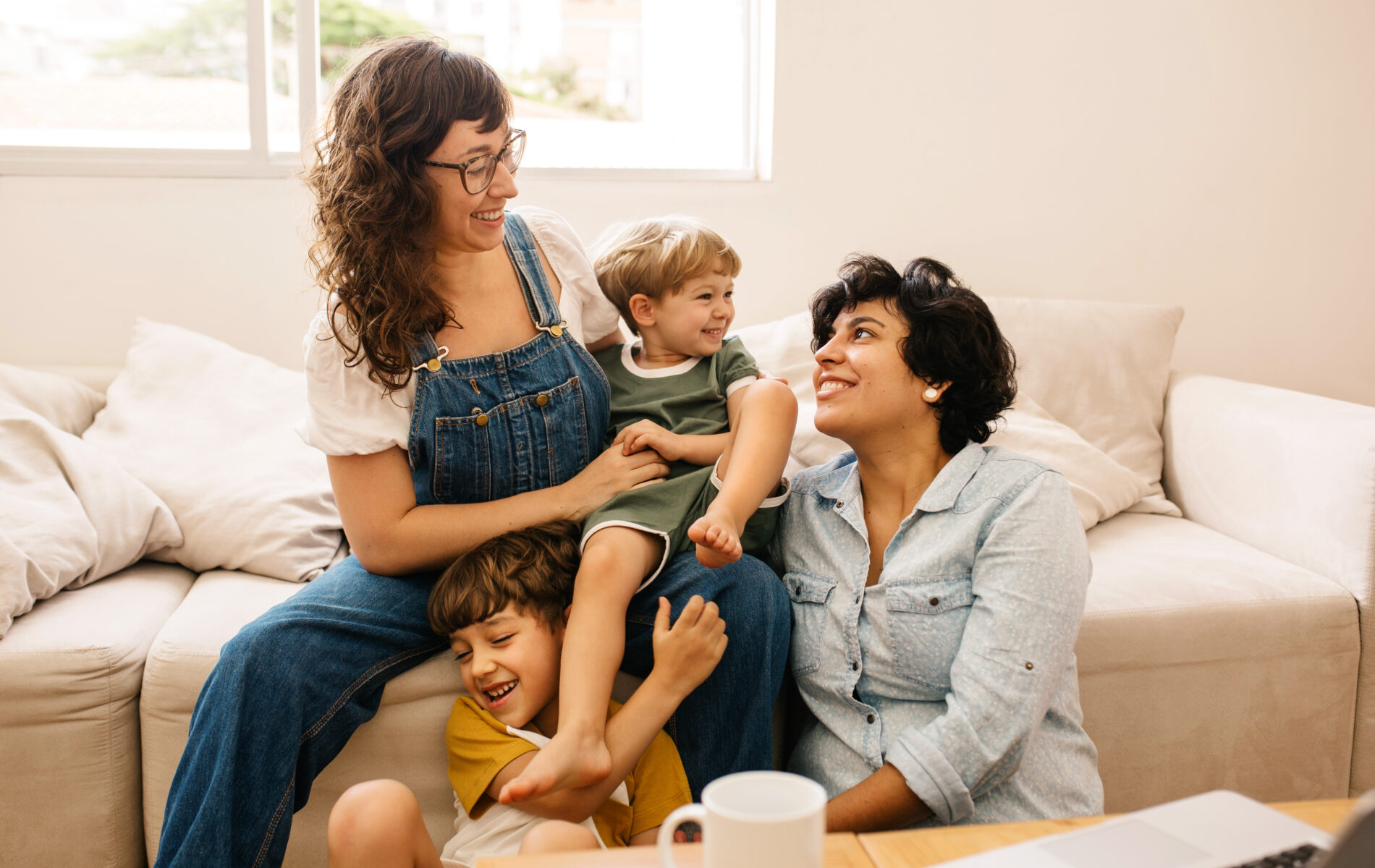 Happy family laughing together on a cozy living room couch.