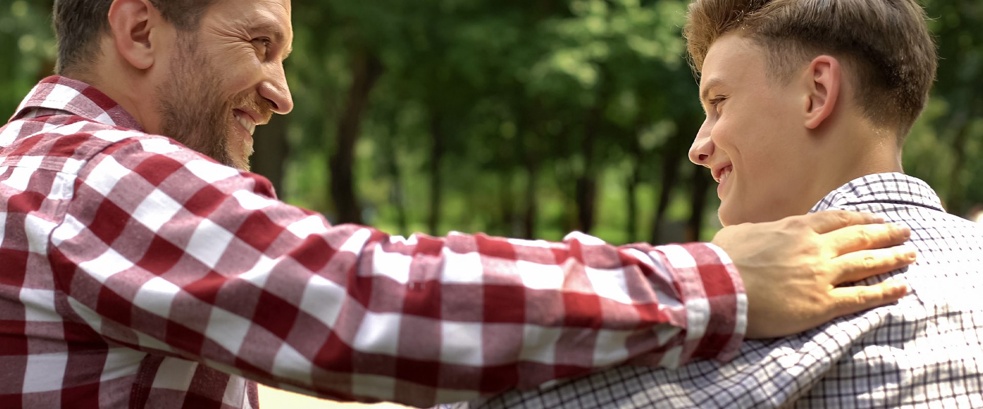 Un parent et son enfant profitent d'un moment sûr dans un espace extérieur, qui constitue une étape du processus complexe et non linéaire de la sortie du placard de l'enfant.