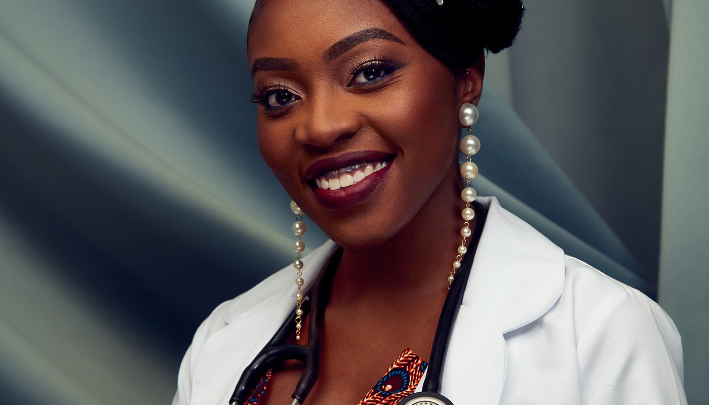 Smiling doctor in a lab coat with stethoscope and elegant hairstyle.