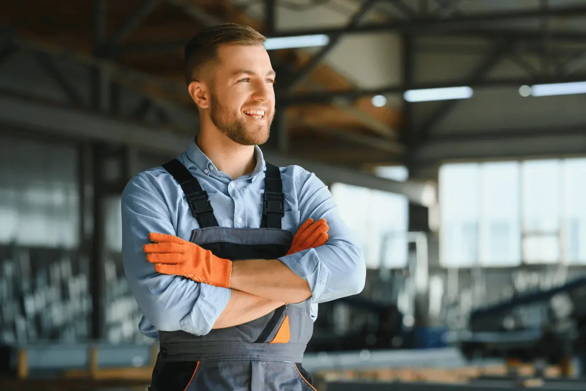 Industrial worker wearing safety gear smiling confidently, representing positive mental health at work