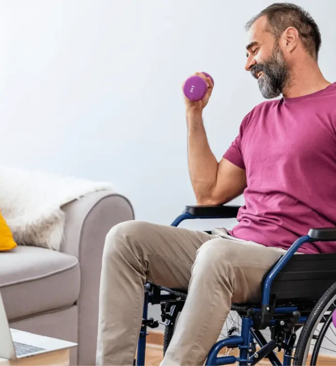 Man in wheelchair performing adaptive strength training with dumbbells during online fitness session at home, part of inclusive workplace wellness program.
