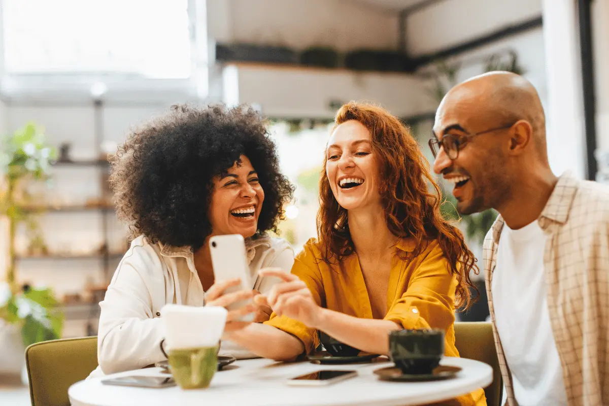 Friends laughing together at work, illustrating the link between friendship and mental health