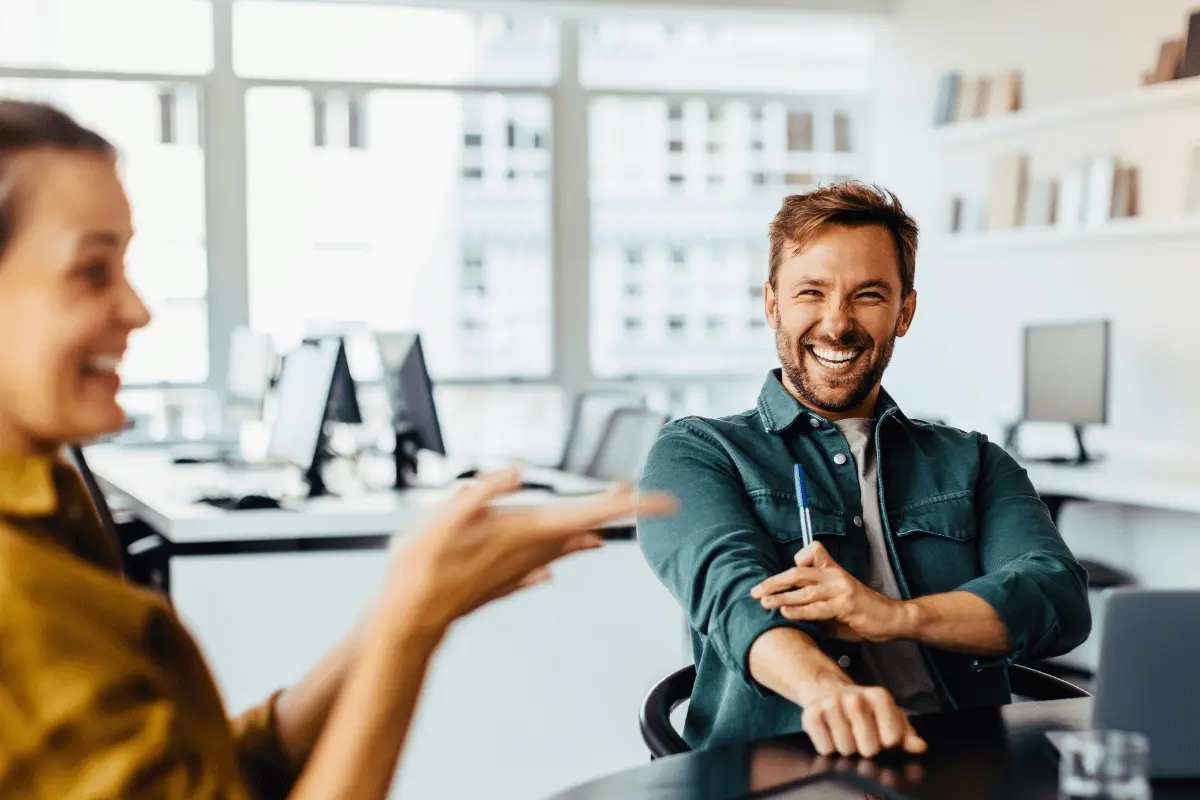 Man smiling in a workplace meeting, representing gratitude and team wellbeing