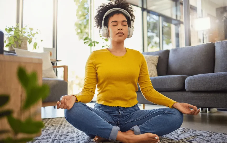 Employee practicing mindfulness at home with headphones—an example of accessible wellbeing in the workplace.