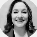 Smiling woman with curly hair and a blazer in a black and white headshot.