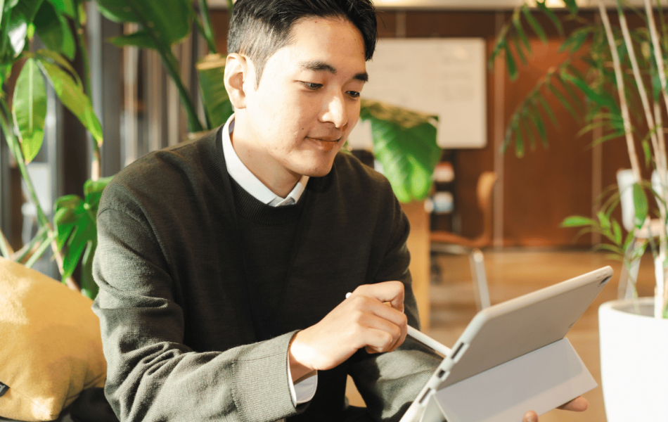 A person reviewing information on a tablet in a bright office setting, representing clear and accessible benefits communication during open enrollment