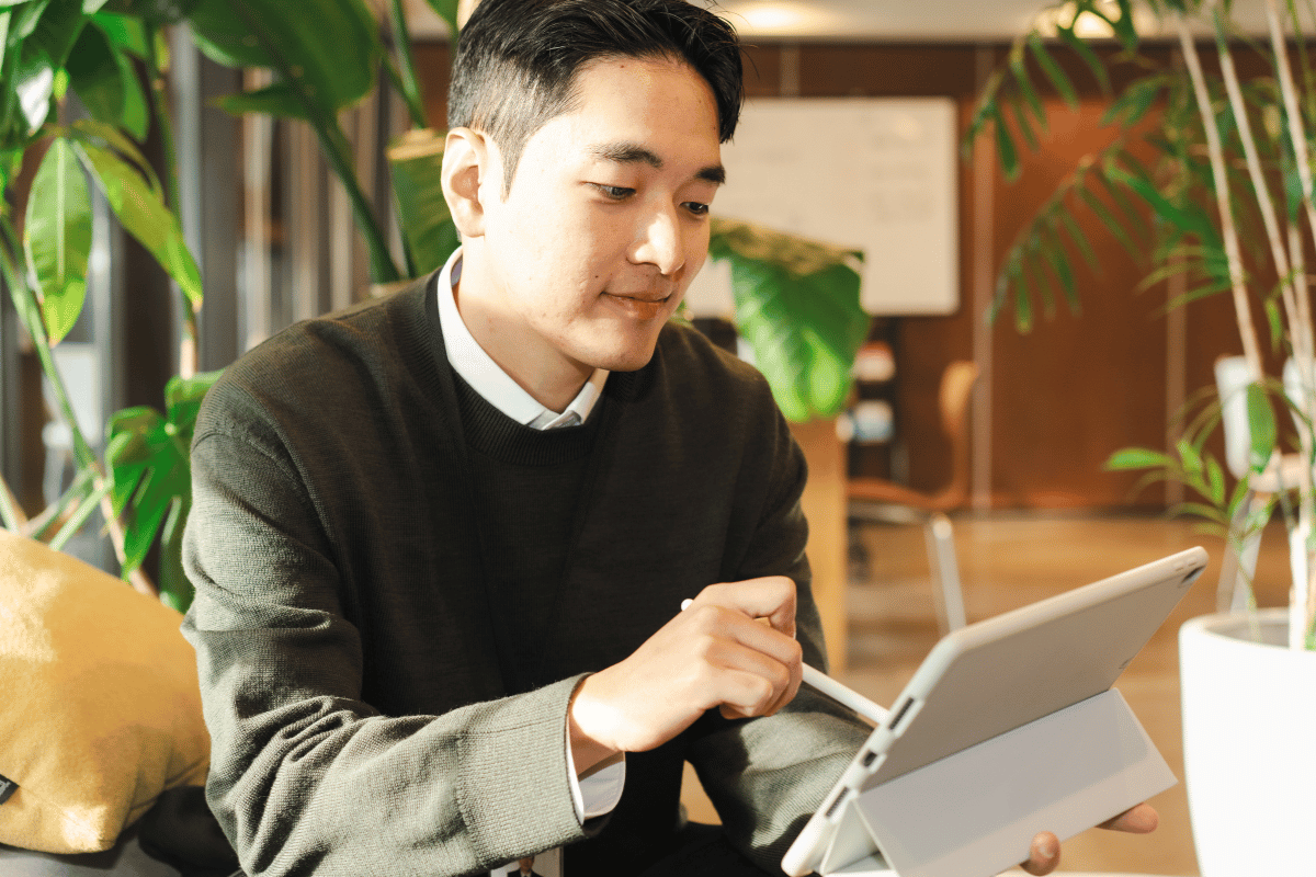 A person reviewing information on a tablet in a bright office setting, representing clear and accessible benefits communication during open enrollment