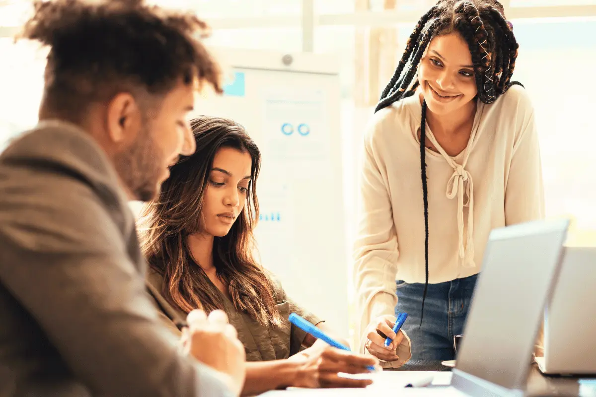 Three diverse managers in a team meeting discussing workplace wellbeing and mental health strategies