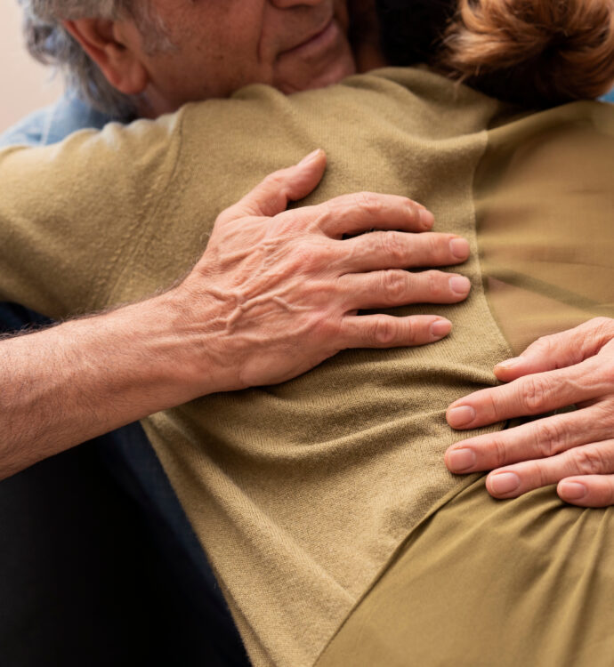 Warm embrace between two people showing comfort and connection indoors.